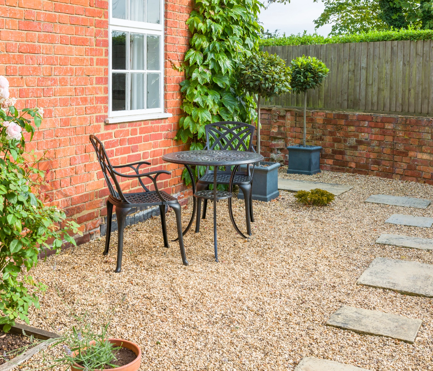 backyard red brick house stone and pea gravel patio