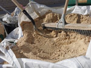 Bag of sand, shovel and helmet, break work on site construction. construction sand, shovel, bag