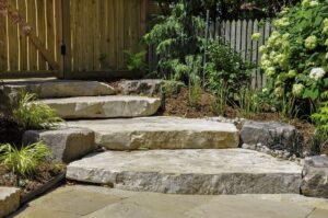 Oversized natural stone steps create a natural entrance to an urban garden with topsoil