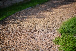 Footpath built with pea pebbles with side green grass