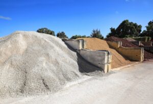 Bulk quantities of different landscaping rocks, recycled concrete, stones, sand and fill for sale at a local supply shop.