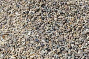 Pebble stone surface – natural texture of small rounded gravel in neutral earthy tones background